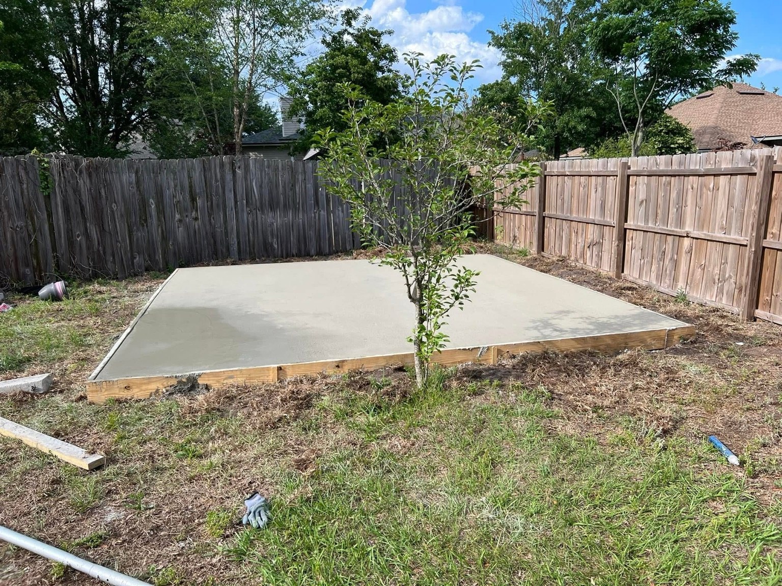 Finished concrete slab in a fenced backyard