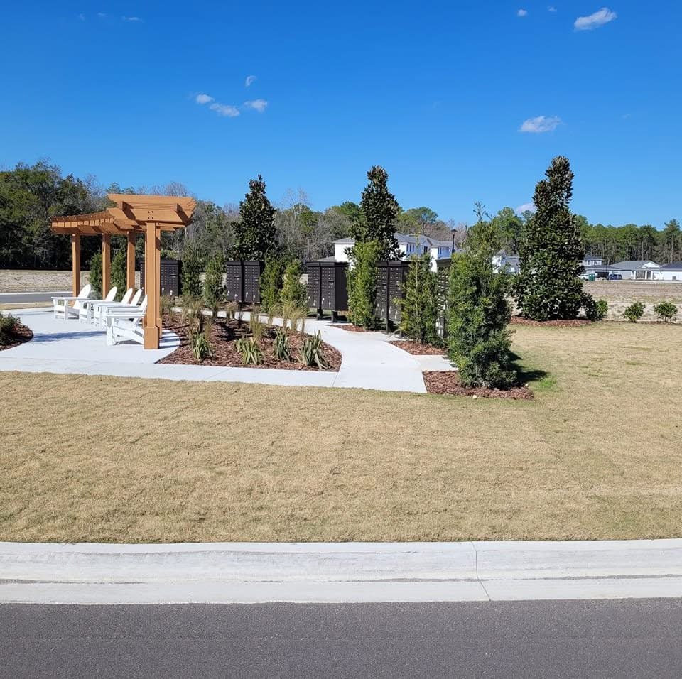 Landscaped outdoor area with pergola and concrete paths