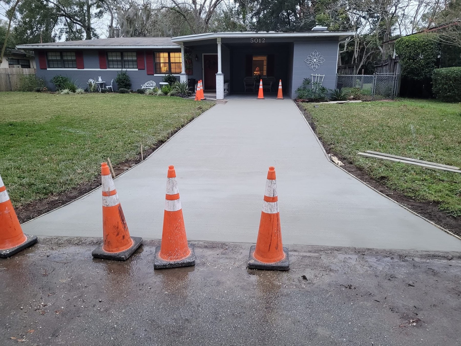 New concrete driveway leading to a residential carport